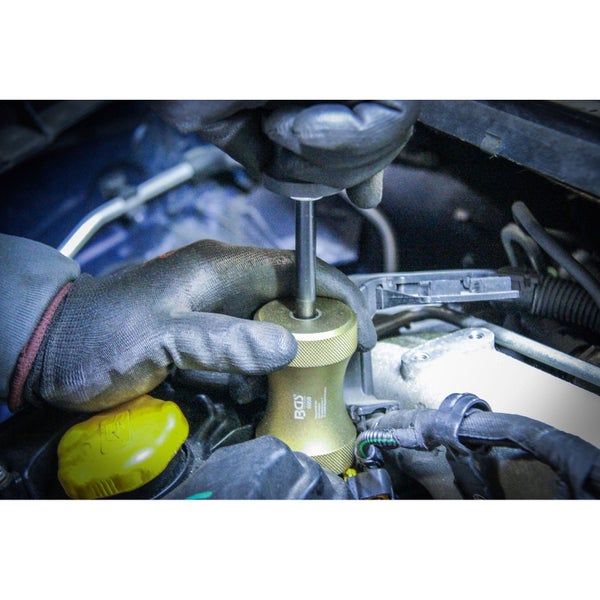 Ein Mechaniker verwendet ein BGS Werkzeug im Motorraum eines Autos.