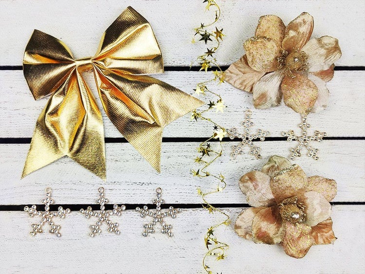 Weihnachtsbaumschmuck Set bestehend aus einer Schleife, künstlichen Blumen, Sternanhängern und Sternengirlande.