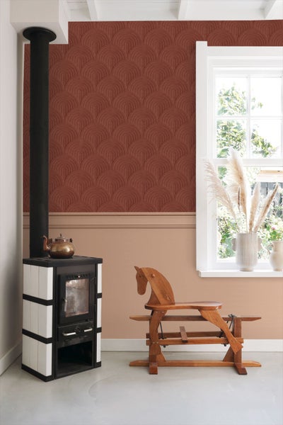 Wohnraum mit Ofen, Holzpferd und gemusterter Tapete