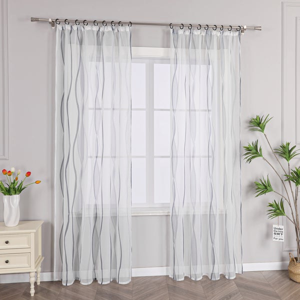 Fensterszene mit transparenten Vorhängen mit Wellenmuster an einer Gardinenstange
