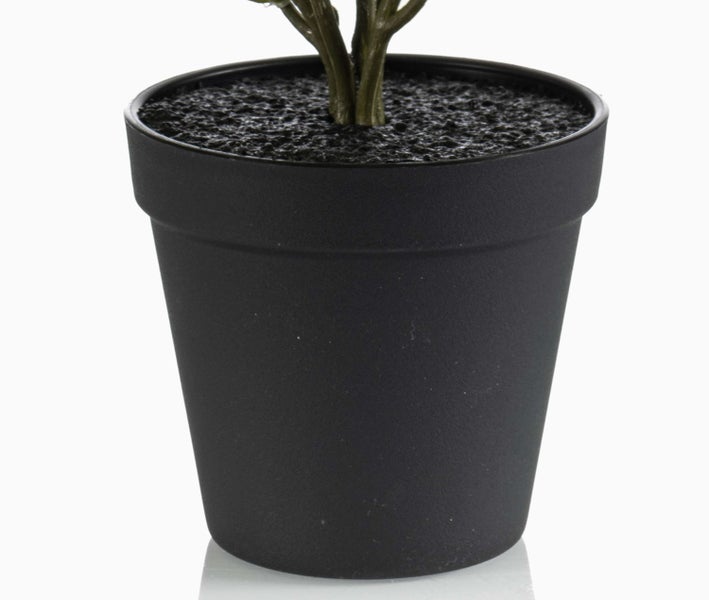 Schwarzer Blumentopf mit künstlichem Pflanzenstiel und dunkler, strukturierter Oberfläche.