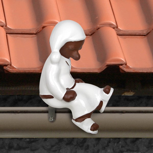 Braune und weiße Dachfigur Schlafmütze aus Keramik, sitzend an einer Dachrinne montiert.