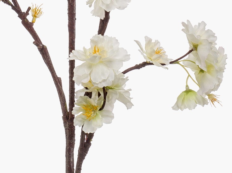 Künstlicher Kirschblütenzweig mit weißen Blüten und gelber Mitte an einem braunen Ast.