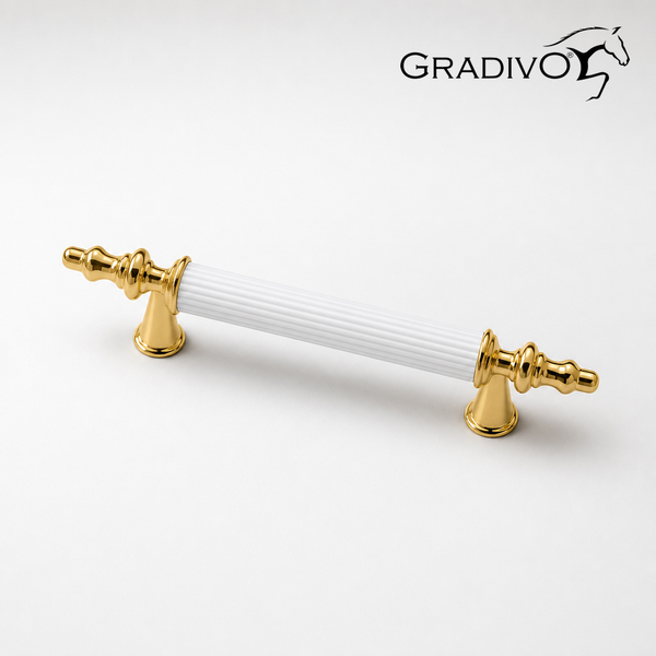 Gradivo Logo. Möbelgriff aus Metall und weißer Keramik mit geriffelter Oberfläche und verzierten goldfarbenen Enden.