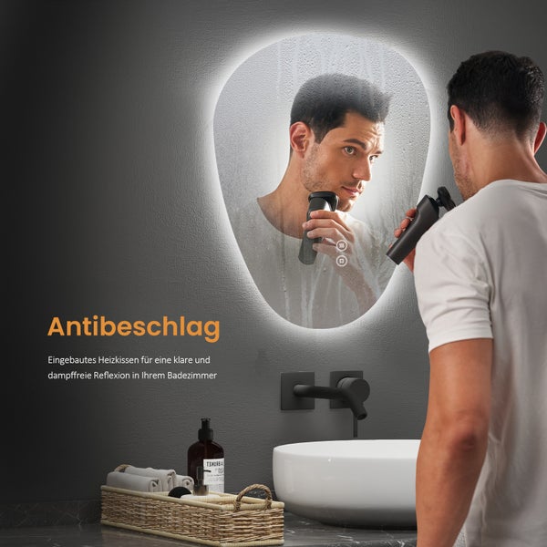 Badezimmer mit beleuchtetem Spiegel mit Antibeschlagfunktion, Waschtisch und Mann beim Rasieren
