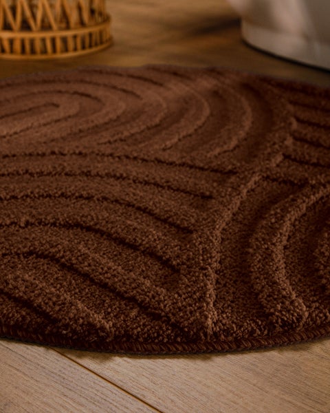 Badematte mit geometrischem Relief-Muster aus Quadraten und Kurven in Beige, weiche Textur.