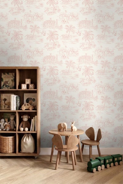 Vlies-Tapete mit Safari-Motiven wie Elefanten und Zebras in einem hellen Kinderzimmer mit Holzmöbeln und Spielzeug.