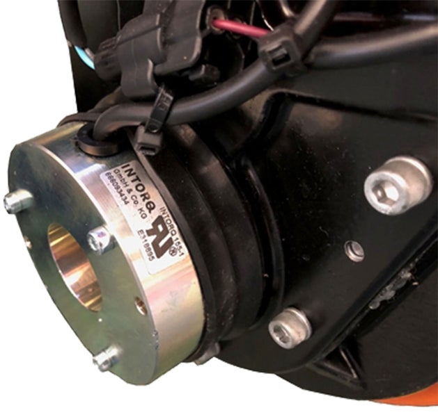 Nahaufnahme einer Intorq Elektromagnetbremse mit Metallflansch, Befestigungsschrauben und elektrischer Verkabelung.