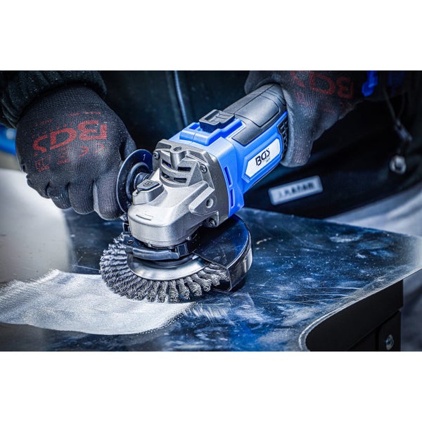 Person schneidet ein Metallrohr mit einem blauen Winkelschleifer, sichtbarer Funkenflug, mit schwarzen Arbeitshandschuhen.