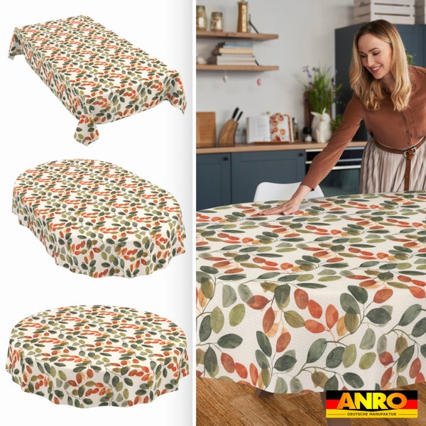 Abwaschbare Tischdecke mit Blättermuster in eckig, oval und rund. Eine Frau deckt einen Tisch in der Küche. ANRO Logo.
