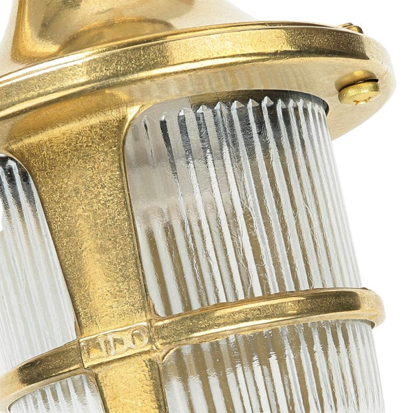 Detailansicht einer goldenen Wandleuchte mit geriffeltem Lampenglas