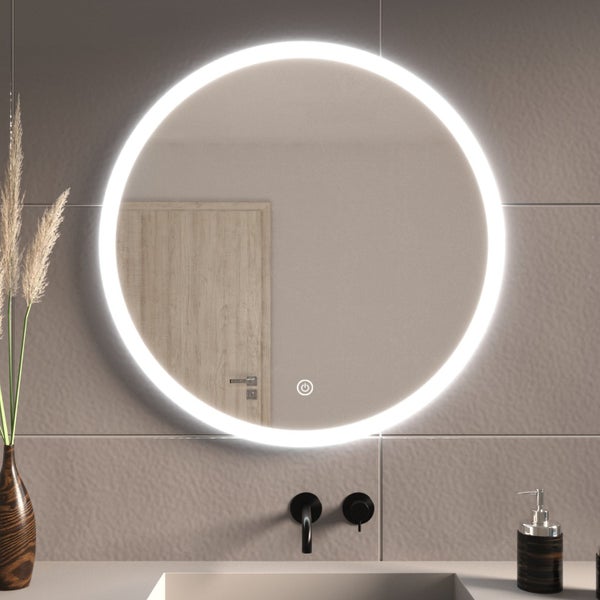 Runder LED Badezimmerspiegel mit integrierter Beleuchtung und Touch Sensor auf einer Fliesenwand über einem Waschbecken.