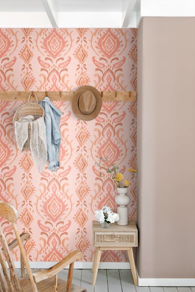 Raumansicht mit gemusterter Tapete, Garderobe und Dekoration