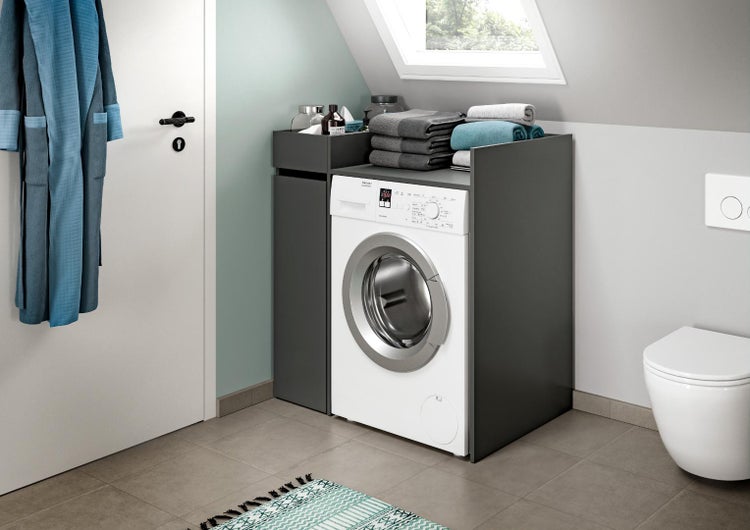 Waschmaschinenumbauschrank in einem modernen Badezimmer mit Waschmaschine und Ablagefläche für Handtücher.