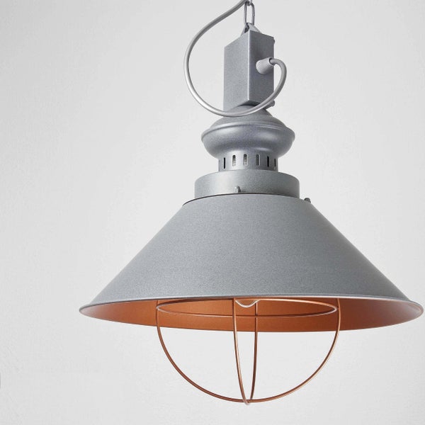 Graue Pendelleuchte aus Metall im Industrie-Design mit kegelförmigem Schirm, kupferfarbener Innenseite und Drahtkorb.