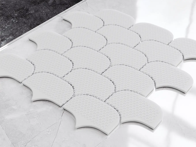 Weiße Mosaikfliesen in Fischschuppen-Form aus Keramik mit strukturierter Oberfläche.