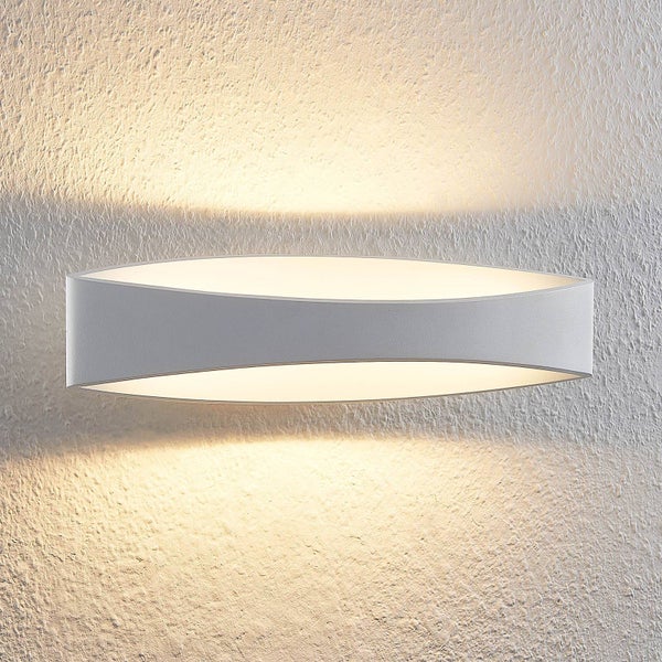 Moderne LED-Wandleuchte in geschwungener Form aus Metall mit Lichtaustritt nach oben und unten an einer strukturierten Wand.
