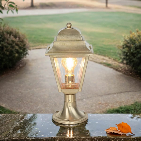 Goldene Sockelleuchte mit eingeschalteter Glühbirne im Außenbereich