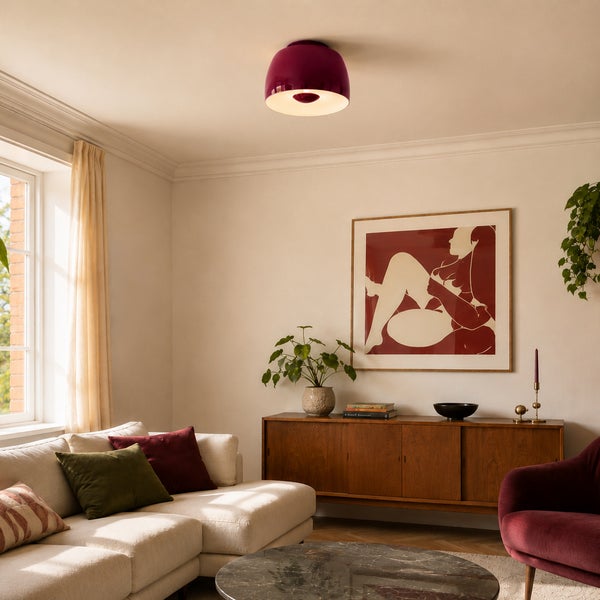 Halbrunde Deckenleuchte in einem modern eingerichteten Wohnzimmer mit Sofa und Sideboard.