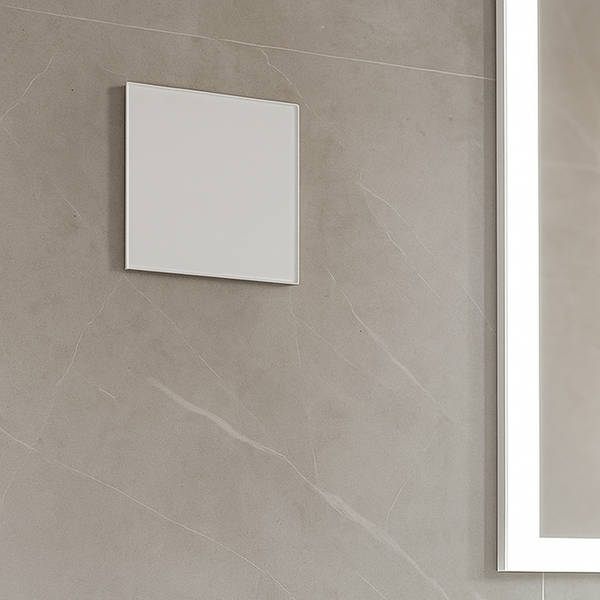 Quadratischer Badlüfter an einer Wand mit großformatigen grauen Fliesen in Steinoptik neben einem Leuchtspiegel.