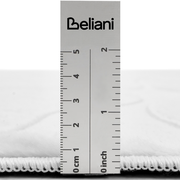 Beliani Logo auf einem Lineal zur Darstellung der Florhoehe eines Teppichs mit metrischer und zölliger Skala