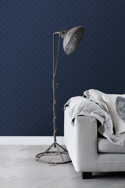 Wohnzimmer mit gemusterter Tapete, Stehlampe und Sofa.