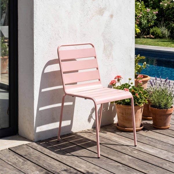 Moderner Gartenstuhl aus Metall mit Lattendesign auf einer Holzterrasse neben Pflanzen und einem Pool.
