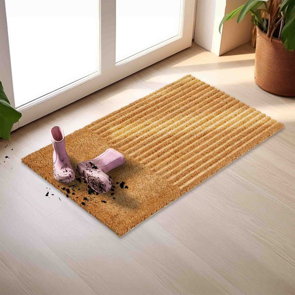 Fußmatte aus Kokosfaser mit Gummistiefeln vor einer Tür