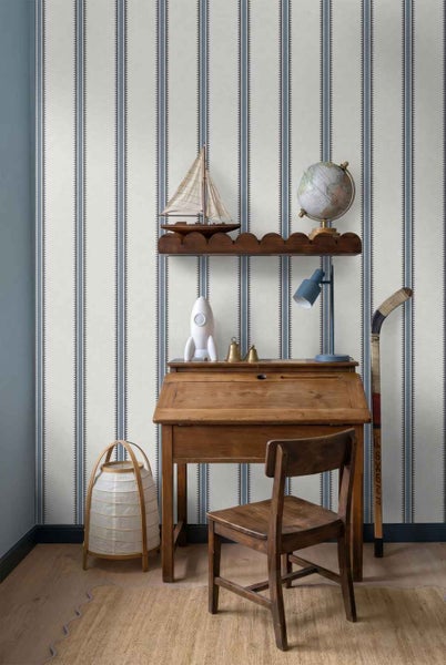 Vliestapete mit klassischem Streifenmuster in einem Kinderzimmer mit Holzschreibtisch, Stuhl und dekorativen Accessoires.