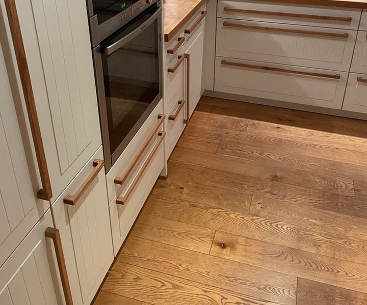 Küchenszene mit Einbaubackofen und Schränken mit Holzgriffen