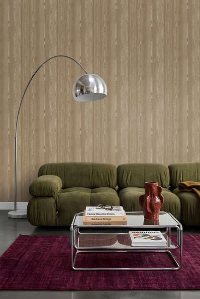 Wohnzimmer mit Tapete in Holzoptik, grünem Sofa, Stehlampe, Glastisch und Teppich im modernen Design.