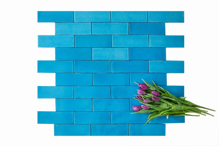 Blaue rechteckige Wandfliesen im versetzten Verbund mit Tulpenstrauß.