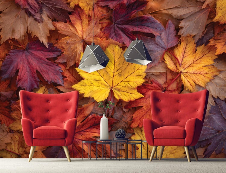Dekorative Wand mit Herbstlaub-Fototapete, zwei roten Sesseln und zwei Lampen