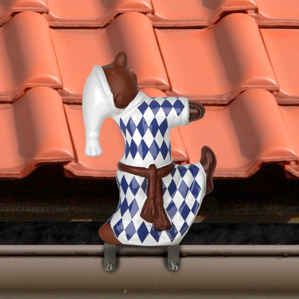 Keramische Firstfigur Schlafmütze mit blau-weißem Rautenmuster auf einem Ziegeldach.