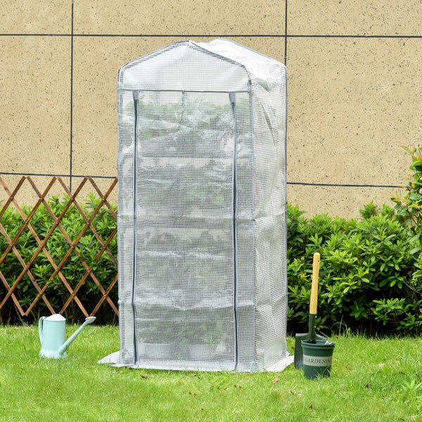 Kompaktes Foliengewächshaus im Garten auf Rasenfläche neben einer Gießkanne, einem Gartenwerkzeug und einem Holz-Scherengitter.
