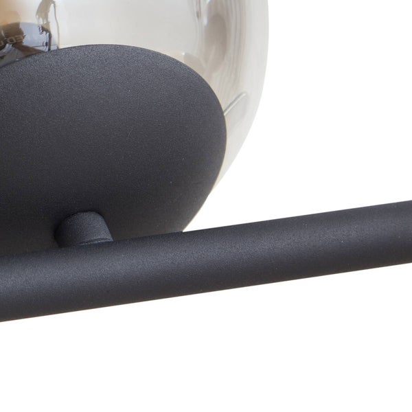 Detailaufnahme einer Deckenleuchte mit schwarzem Metallgestell und Glaskugelschirm.