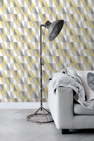 Wohnzimmer mit geometrischer Tapete, Stehlampe und Sofa