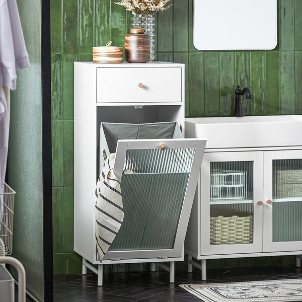 Badezimmer Szene mit weißem Waschbeckenunterschrank, Wäschesammler mit Schublade und geriffelten Glaselementen.