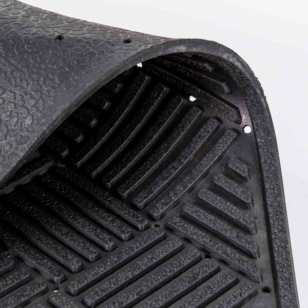 Detailaufnahme einer schwarzen Gummimatte mit Rillenstruktur