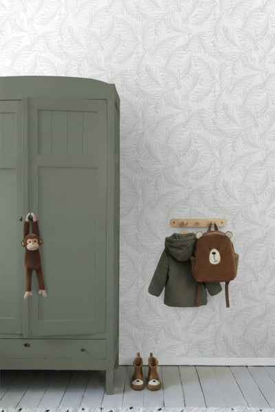 Tapete mit filigranem Blattmuster in einem Kinderzimmer neben einem grünen Holzschrank und einer Garderobe mit Bären-Rucksack.