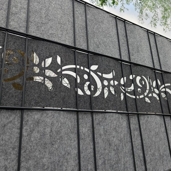 Detailansicht eines Sichtschutzzauns mit grauem Filz und floralem Muster