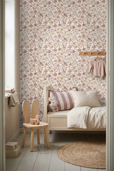 Kinderzimmer mit floraler Tapete, weißem Holzbett, Hasenstuhl aus Holz und rundem Jute-Teppich auf hellem Holzboden.