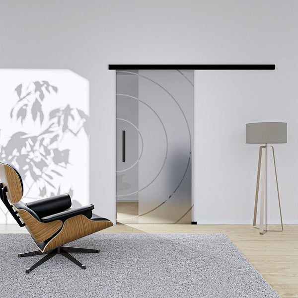 Wohnzimmer mit Glasschiebetür, Sessel und Stehlampe für ein helles Ambiente