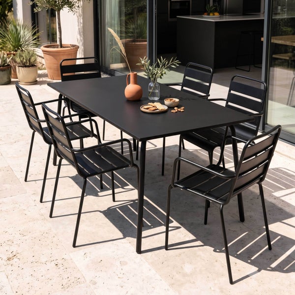 Schwarzes Garten-Essset mit rechteckigem Metalltisch und sechs Stühlen mit Armlehnen auf einer hellen Terrasse.