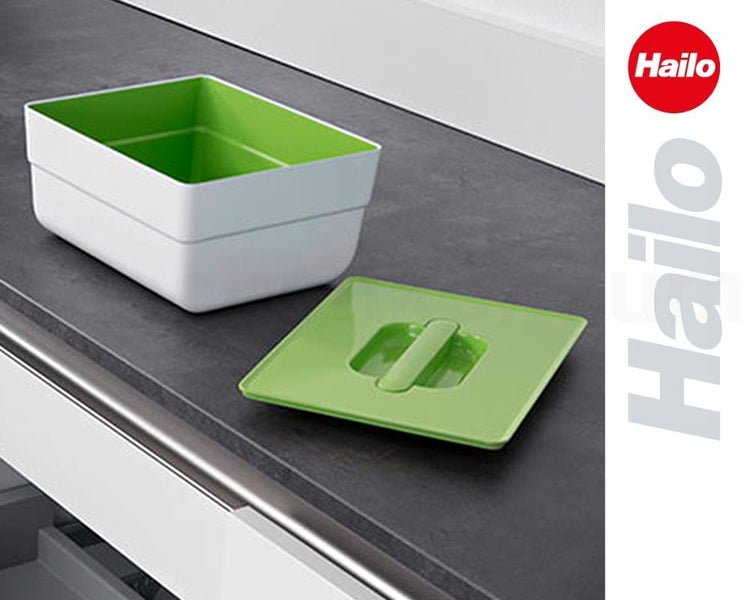 Hailo Logo. Weißer Kunststoff-Bio-Abfalleimer mit grünem Inneneinsatz und grünem Deckel auf einer Küchenarbeitsplatte.