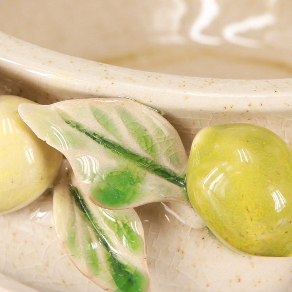 Nahaufnahme einer Keramikschale mit Zitronen- und Blätterdekor