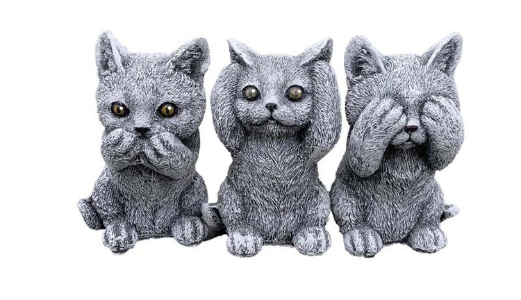 Drei Katzenfiguren aus Stein in der Pose nichts hören, nichts sehen, nichts sagen als Dekoration für den Garten.