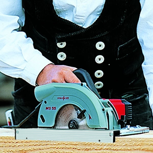 Eine Mafell Handkreissäge Modell MS 55 im Einsatz beim Sägen eines Holzbrettes von einem Handwerker gehalten.