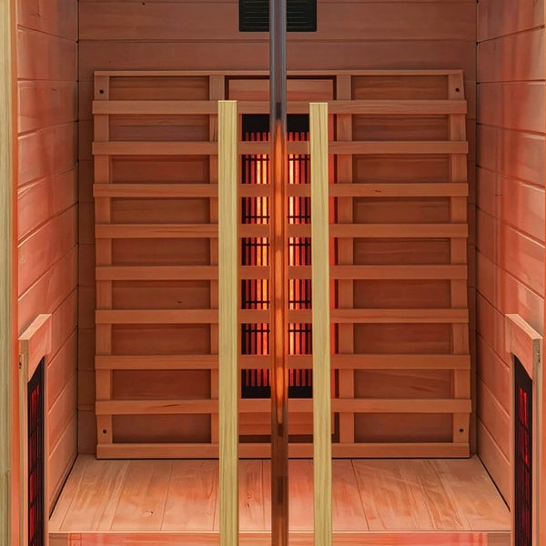 Innenansicht einer Infrarotkabine aus Holz mit sichtbaren Infrarotstrahlern an den Wänden und einem zentralen Holzgitter.