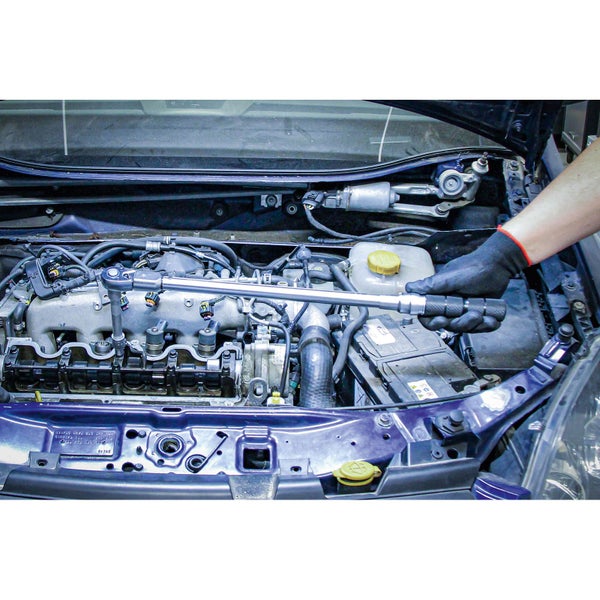 Ein Mechaniker verwendet einen Drehmomentschlüssel, um an einem Automotor zu arbeiten